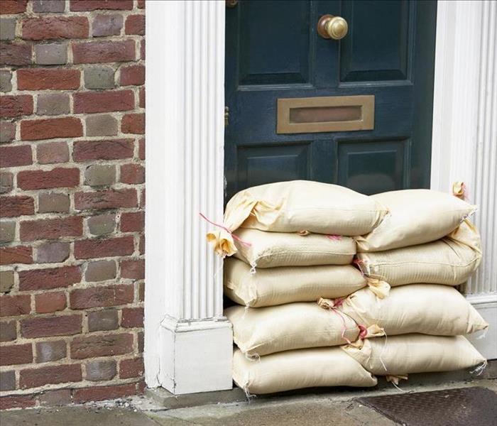 Image of sand bags placed in front of a blue door.