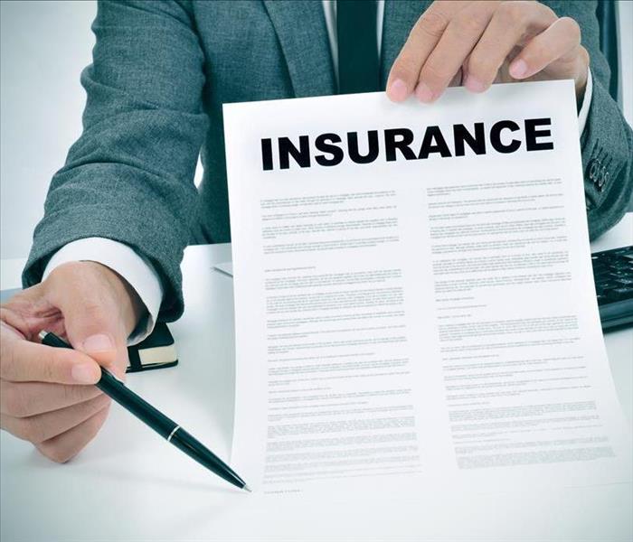 Image of a person holding a paper with a header saying "insurance"